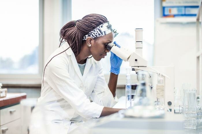 A scientist at a microscope.